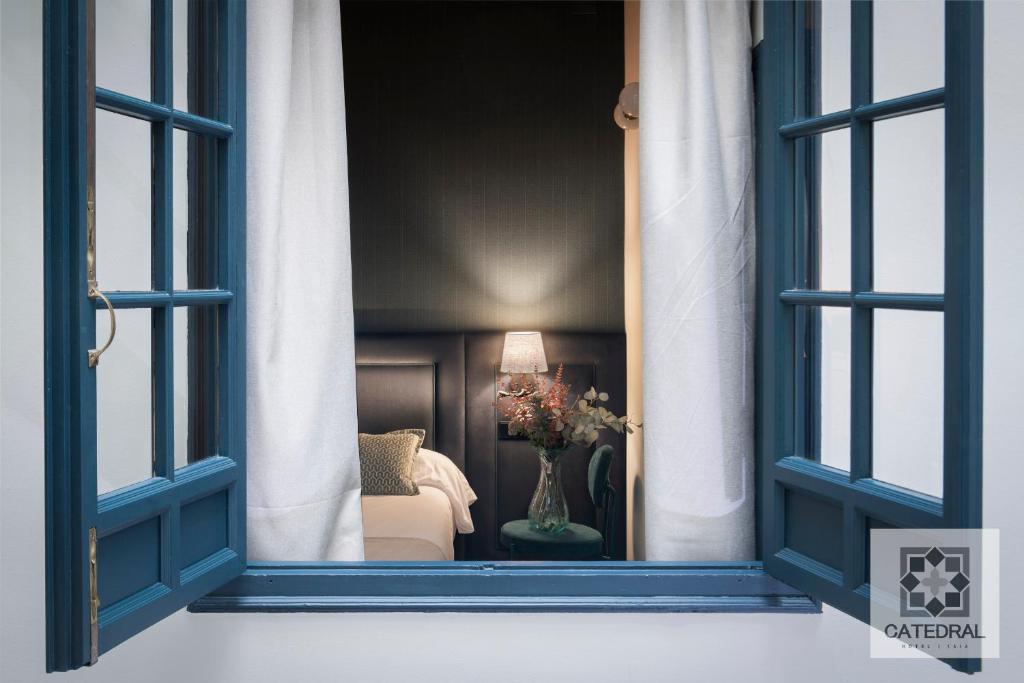 a window view of a room with a chair and a table at Casa Catedral in Seville