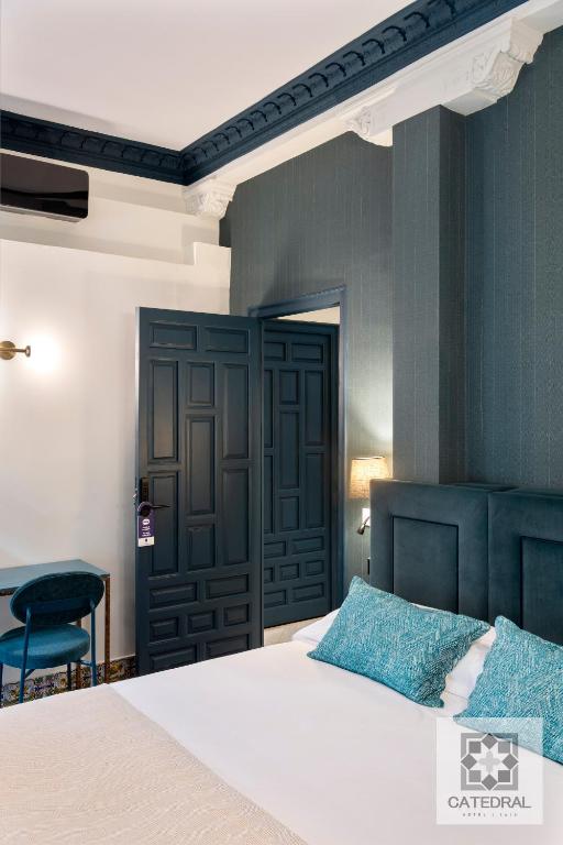 a bedroom with a bed and a black door at Casa Catedral in Seville