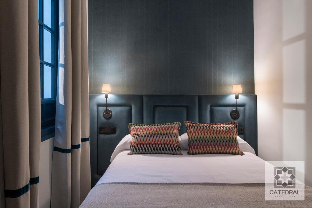 una camera da letto con un grande letto con due cuscini di Casa Catedral a Siviglia