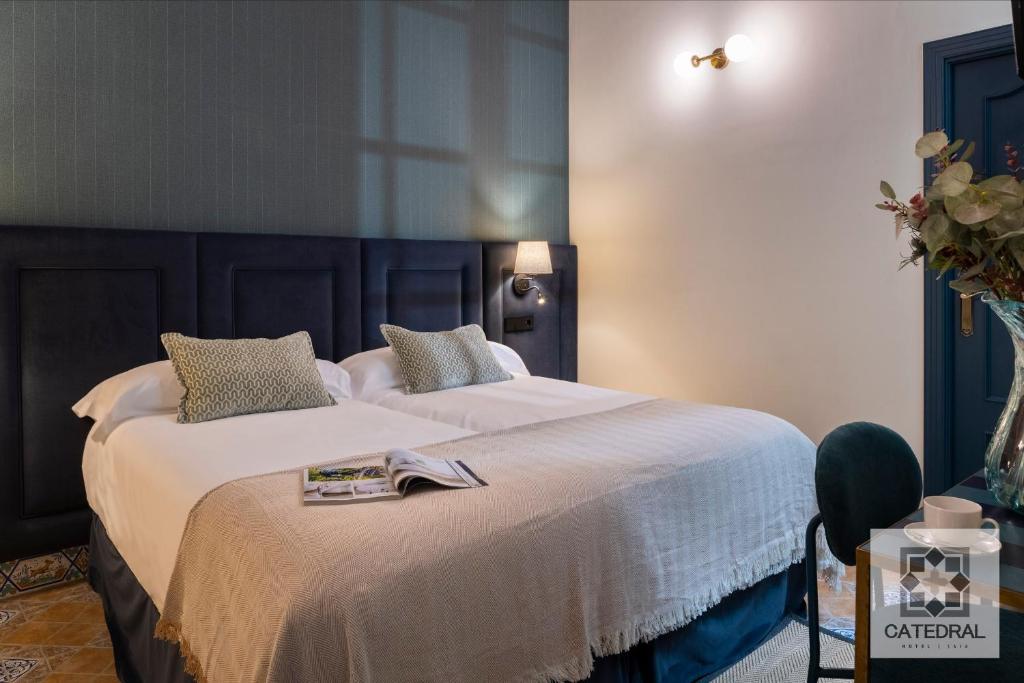 a bedroom with a large bed with white sheets at Casa Catedral in Seville