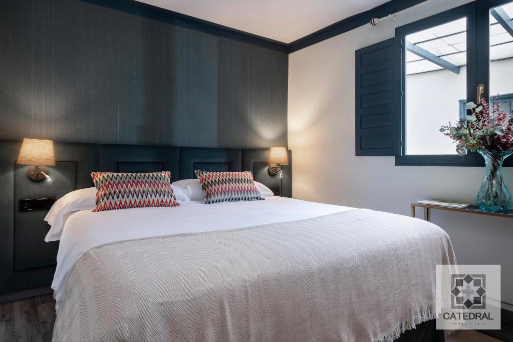 a bedroom with a large white bed with two pillows at Casa Catedral in Seville
