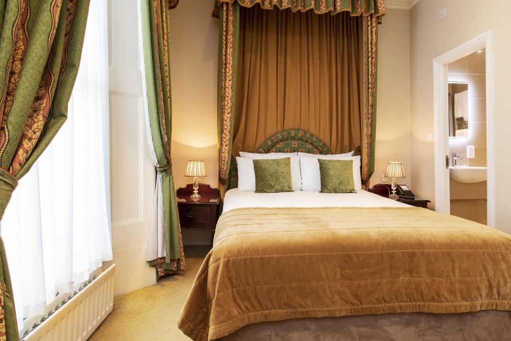 a bedroom with a large bed with a canopy at The Windermere Hotel, London in London