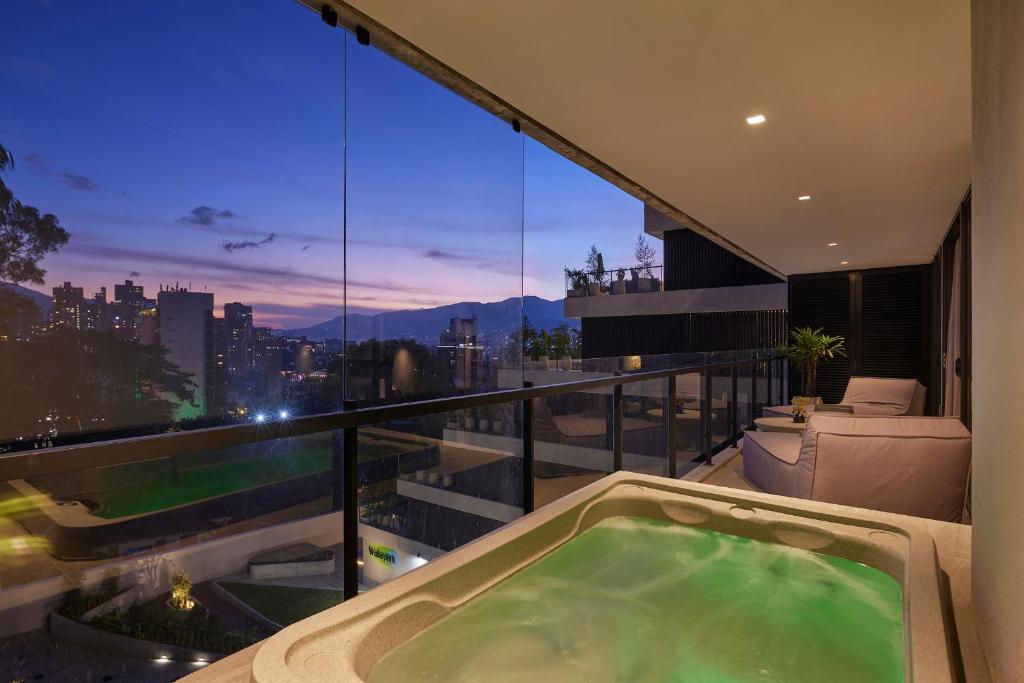 a hot tub on a balcony with a view of the city at Wake - branded residences in Medellín