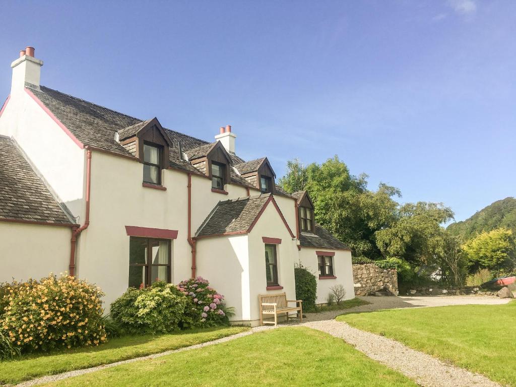 a white house with a bench in the yard at Innish - Uk38783 in Clachan