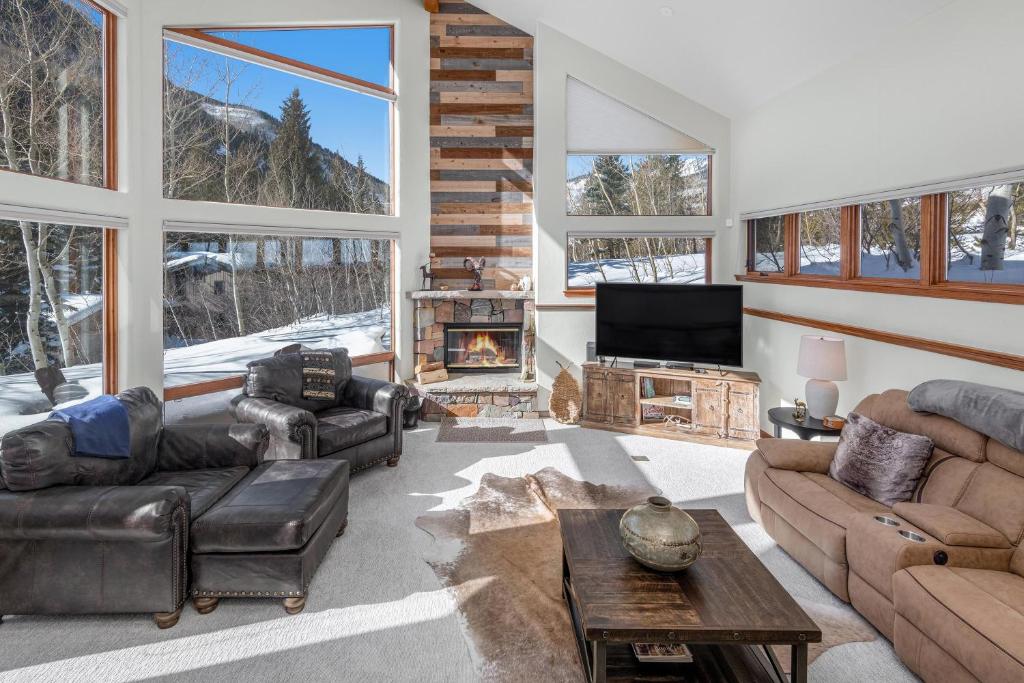 a living room with leather furniture and a fireplace at 4551 Streamside Cir WEST HOUSE in Vail