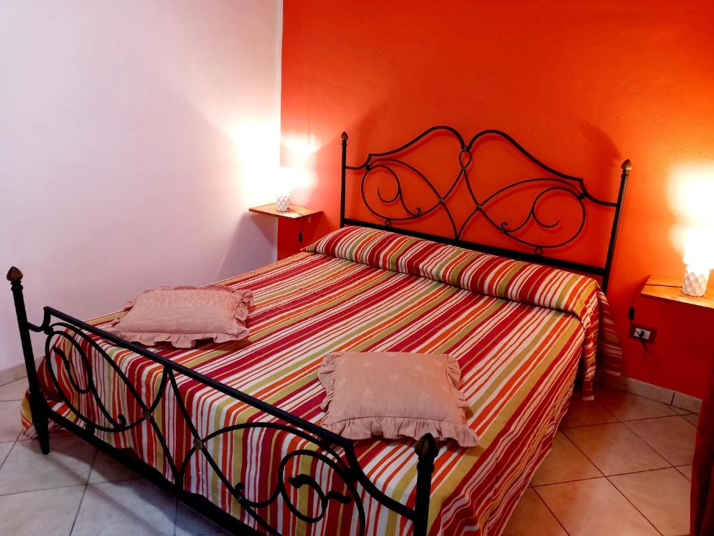 a bedroom with a bed with an orange wall at Celebrity House in Marsala