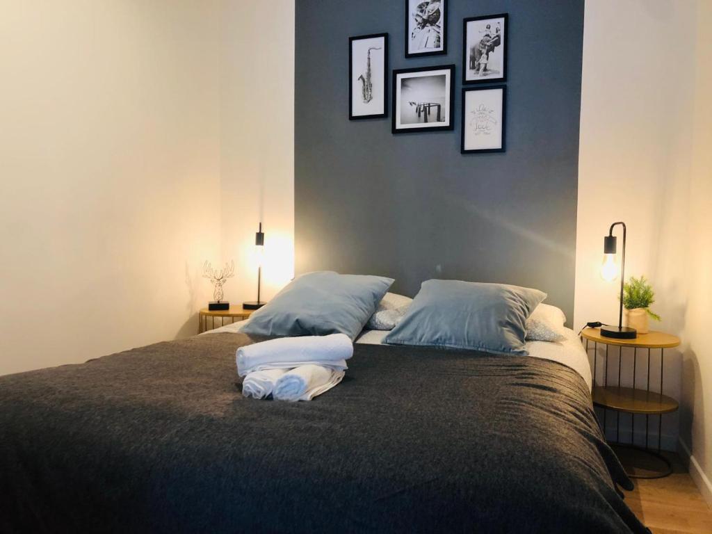 Atelier Arthaud في بريست: غرفة نوم بسريرين مع مخدات وصور على الحائط