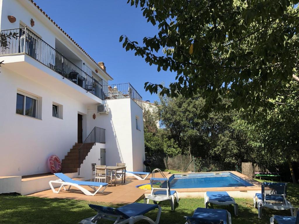 a villa with a swimming pool in front of a house at Villa Rosa in Begur