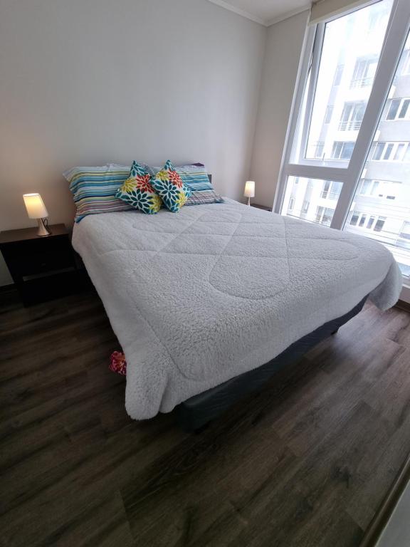 a large bed in a bedroom with a large window at 407/ Precioso apartamento 1D+1B // JUMBO+CENTRO 5 MIN in Puerto Montt