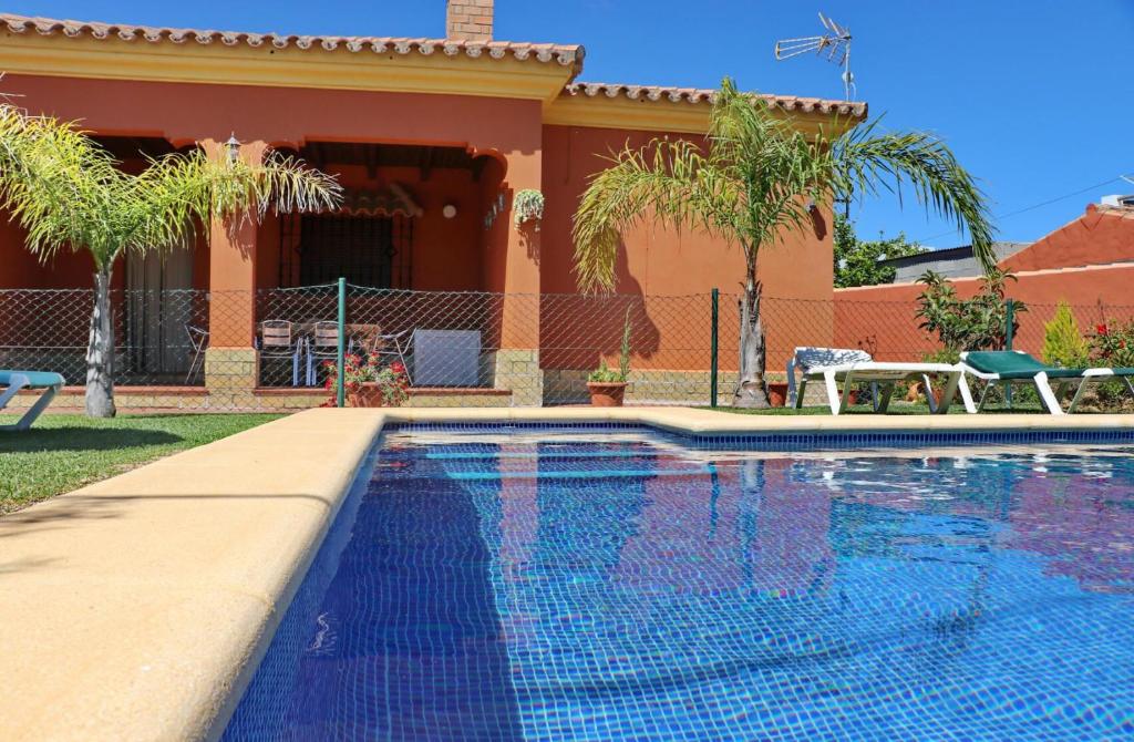 a swimming pool in front of a house at Casa Maestro Roche in Roche