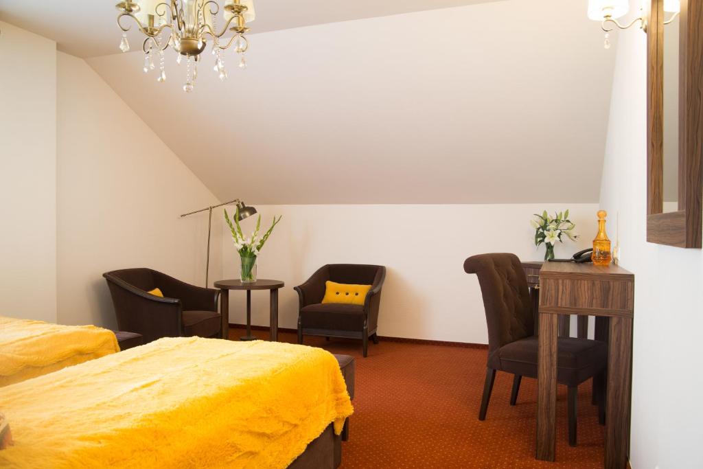 - une chambre avec 2 lits, un bureau et des chaises dans l'établissement Hotel Pasymowski, à Mława