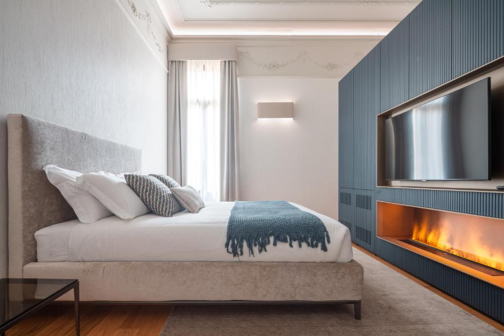 a bedroom with a bed with a fireplace and a tv at Ninfea Luxury Suites in Venice