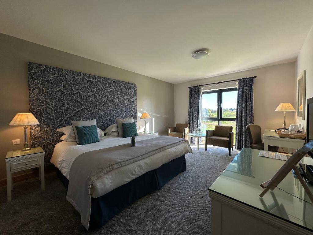 ein Schlafzimmer mit einem großen Bett und einem großen Fenster in der Unterkunft Bicester Hotel, Golf & Spa in Bicester