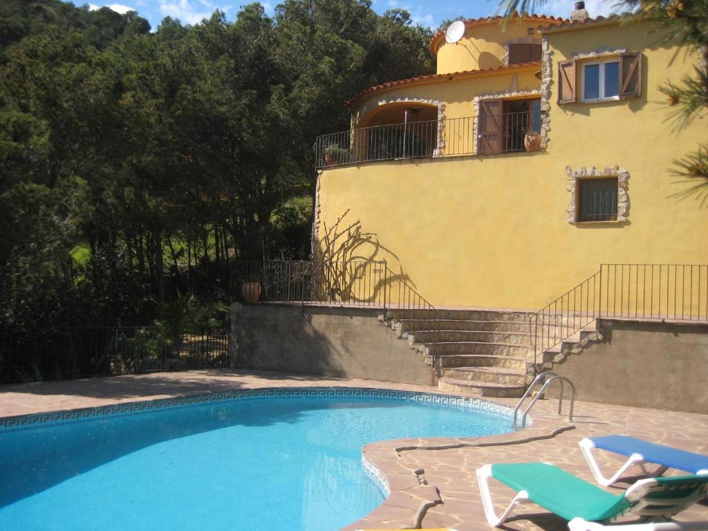a house with a swimming pool next to a building at La gervaise in Begur