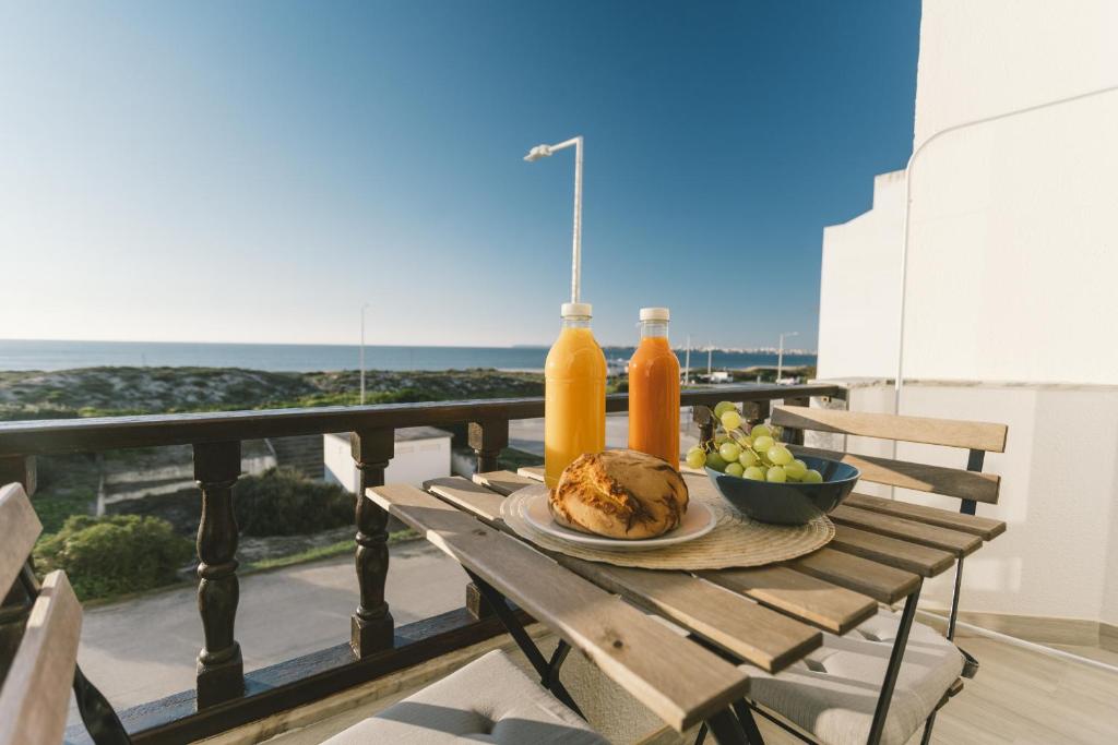 - une table avec jus de fruits et un bol de fruits sur le balcon dans l'établissement Best Houses 53 - Costa Mar II, à Consolação