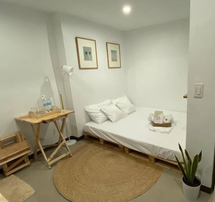 a small bedroom with a bed and a table at The Tiny Room Apartment Units near Anonas and Cubao in Manila