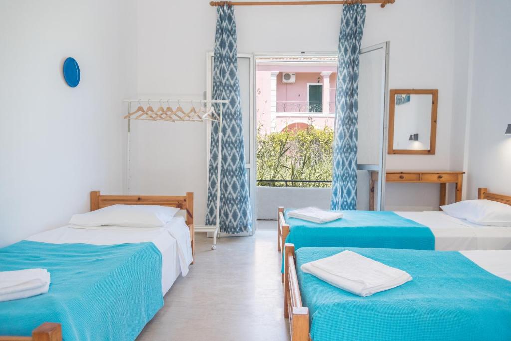 a room with three beds and a window at Seaside Studios in Kavos