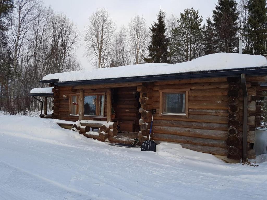 una cabaña de madera con nieve encima en Suvituuli en Kuusamo