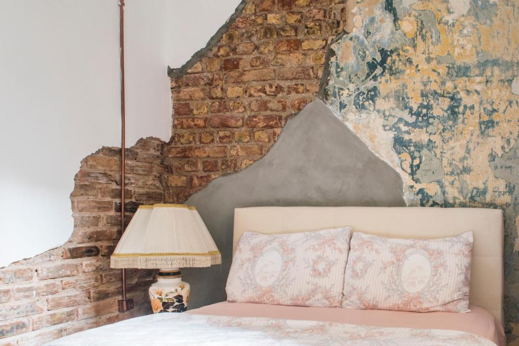 a bedroom with a brick wall and a bed with a lamp at By Galata- Historical and Modern Apartment in Istanbul