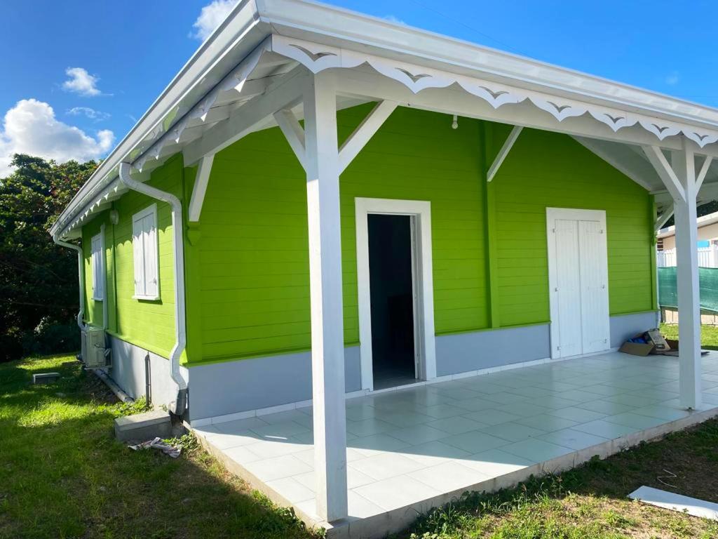 a green house with a white roof at Maison de 2 chambres a Le Vauclin a 500 m de la plage avec jardin clos in Le Vauclin