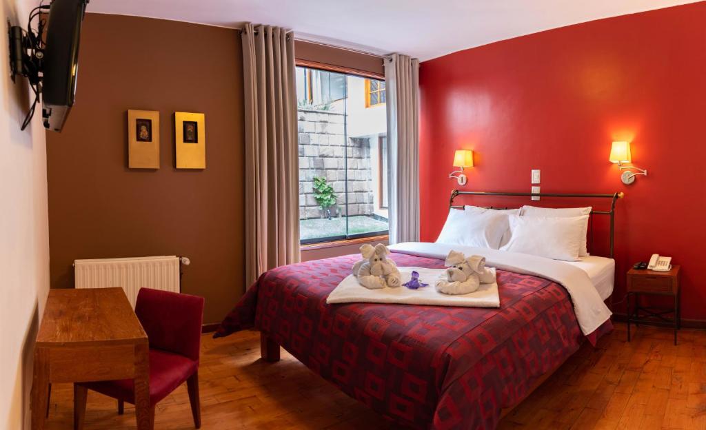 una habitación de hotel con una cama con dos ositos de peluche. en Mamasara Cusco, en Cusco