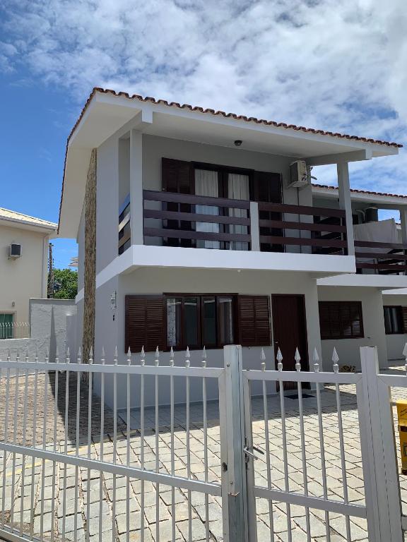 una casa blanca con una valla delante en Duplex Residencial Santos, en Florianópolis