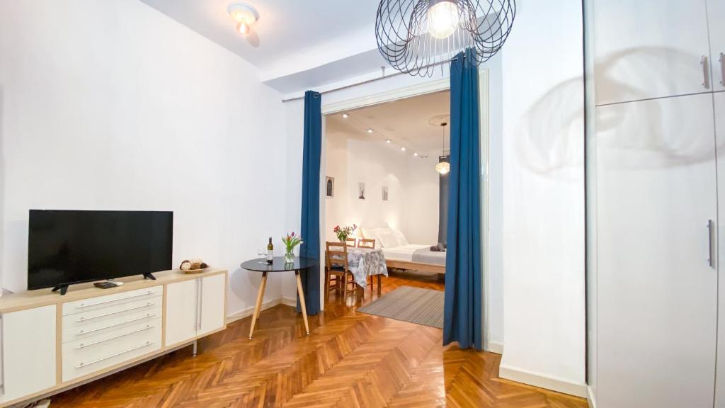 a living room with a tv and a sliding glass door at City Centre Synagogue Residential Apartment Budapest in Budapest