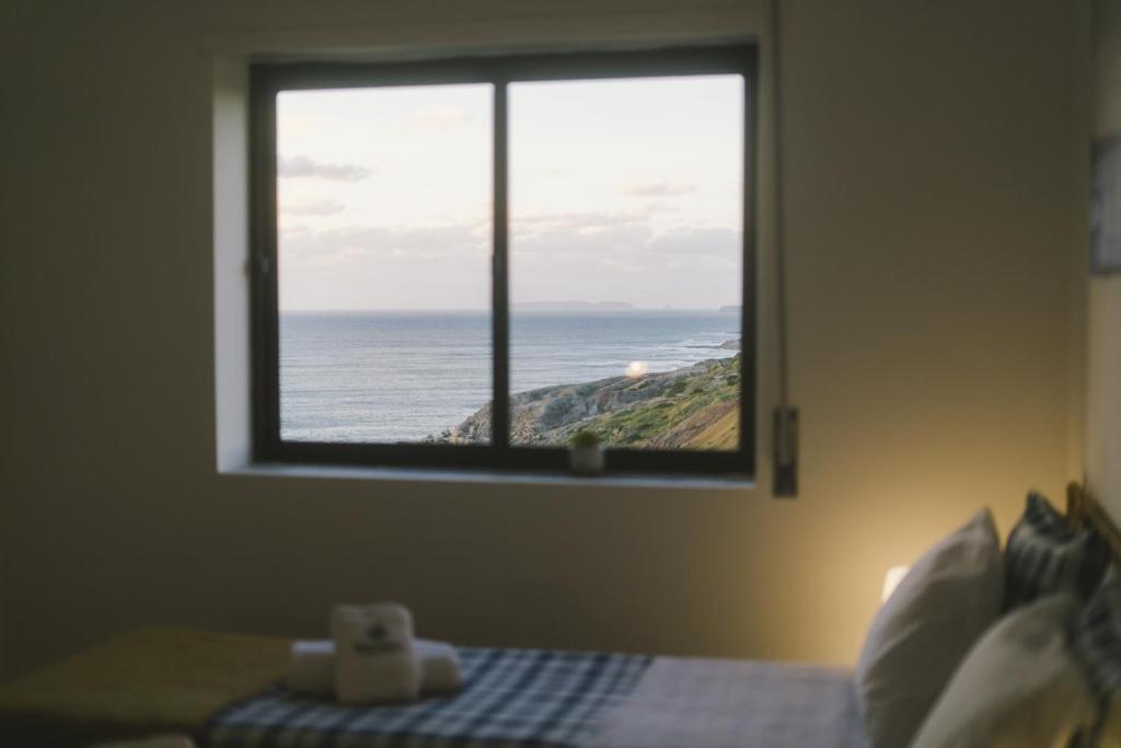 a bedroom with a window with a view of the ocean at Best Houses 73 - Lovely view São Bernardino in Atouguia da Baleia