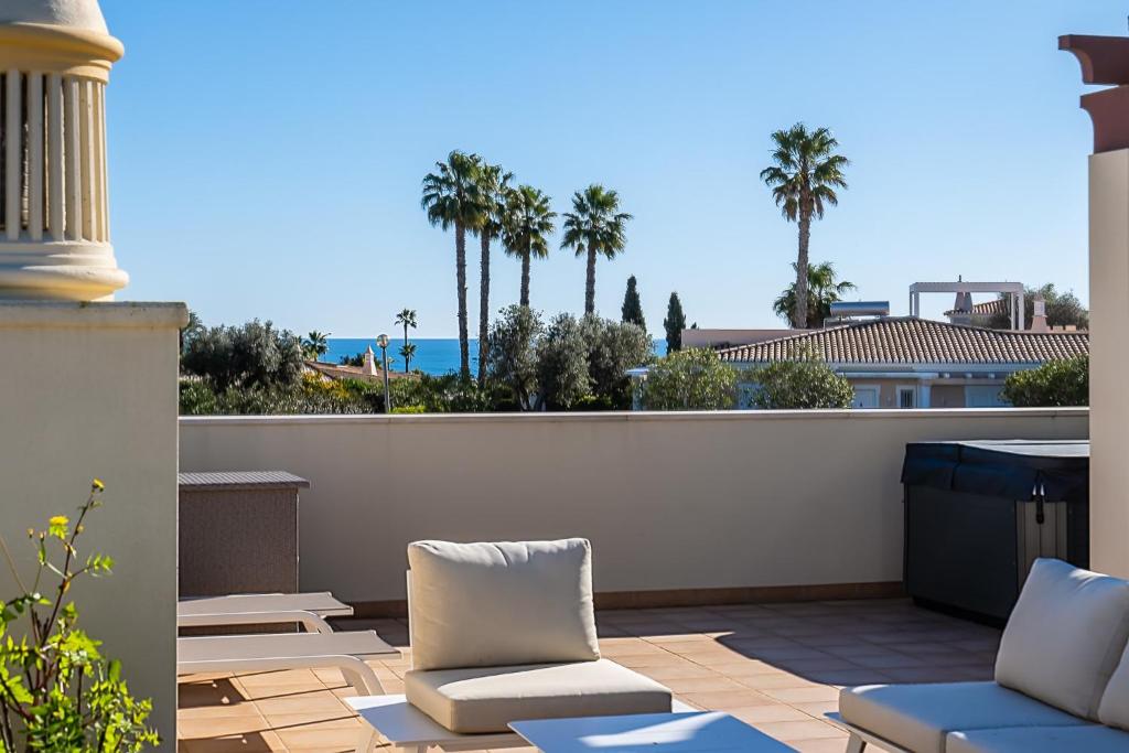 een balkon met stoelen en uitzicht op de oceaan bij Casa Saudade - Luxury penthouse apartment with stunning views in Estômbar