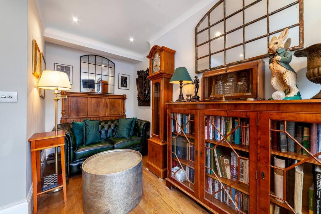 - un salon avec un canapé et une étagère à livres dans l'établissement Outstanding Antique 1BR flat in Soho, à Londres