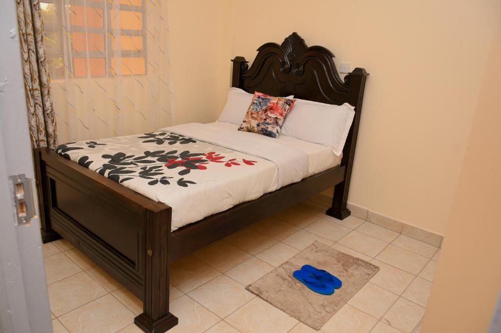 Una cama pequeña en una habitación con un objeto azul. en Classic beautiful 2-Bedroom Apartment in Thika, en Thika