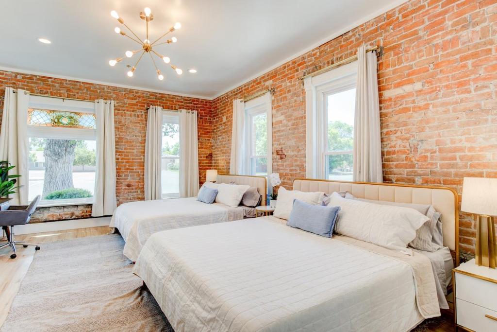 um quarto com 2 camas e uma parede de tijolos em Suite 1 Historic Art City Inn em Springville