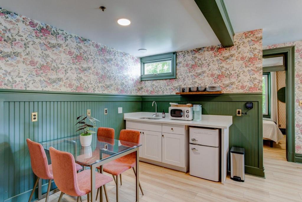 a kitchen with a glass table and orange chairs at Suite 2 Historic Art City Inn in Springville