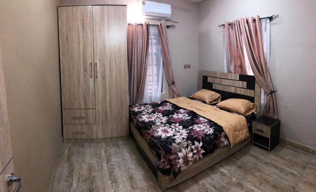 1 dormitorio con 1 cama y vestidor en Montrose Gardens, en Lagos