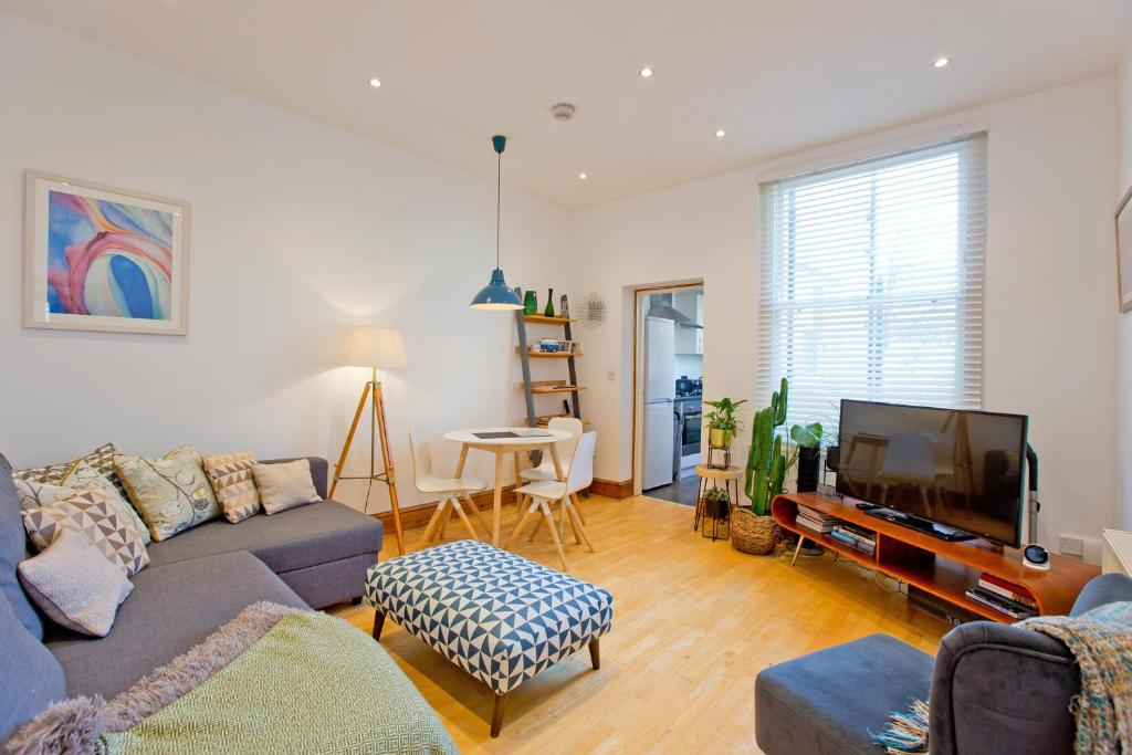 uma sala de estar com um sofá e uma televisão em Calabria 3 - Spacious apartment em Londres