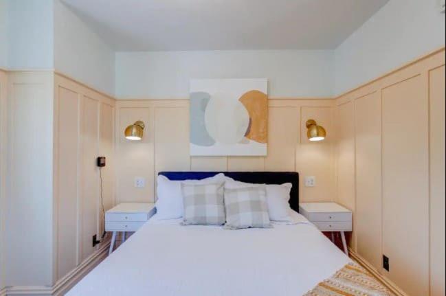 1 dormitorio con 1 cama blanca grande y 2 mesitas de noche en Suite 10 Historic Art City Inn, en Springville