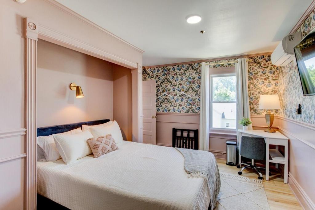 a bedroom with a bed and a desk and a window at Suite 4 Historic Art City Inn in Springville