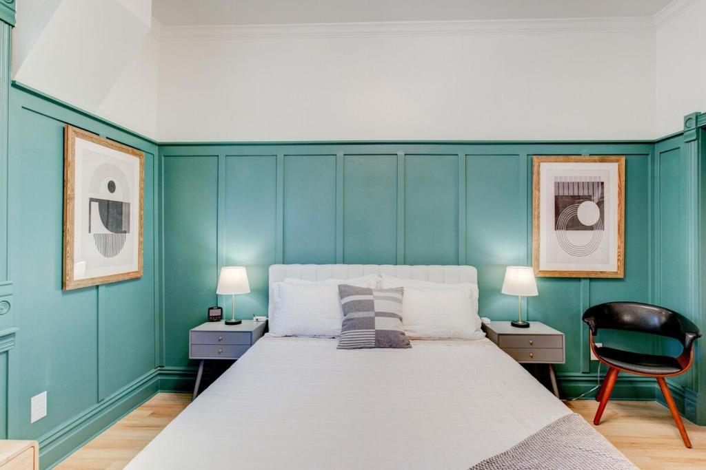 een blauwe slaapkamer met een bed en een stoel bij Suite 6 Historic Art City Inn in Springville