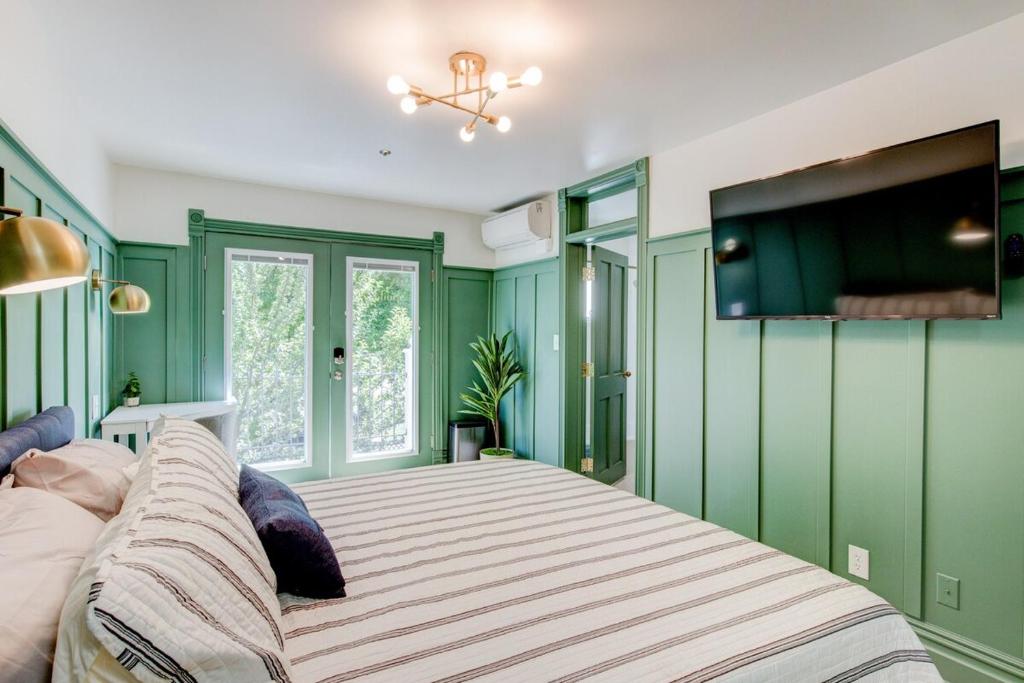スプリングビルにあるSuite 9 Historic Art City Innの緑の壁のベッドルーム1室(大型ベッド1台付)