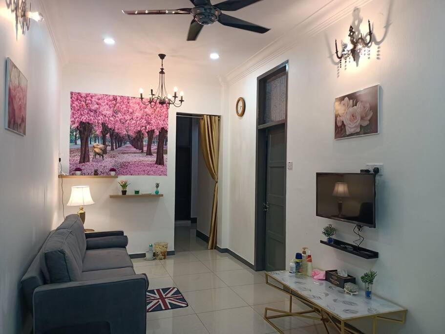 ein Wohnzimmer mit einem Sofa und einem TV in der Unterkunft Sweet 3 bedroom home @ Canning Garden, Ipoh in Ipoh