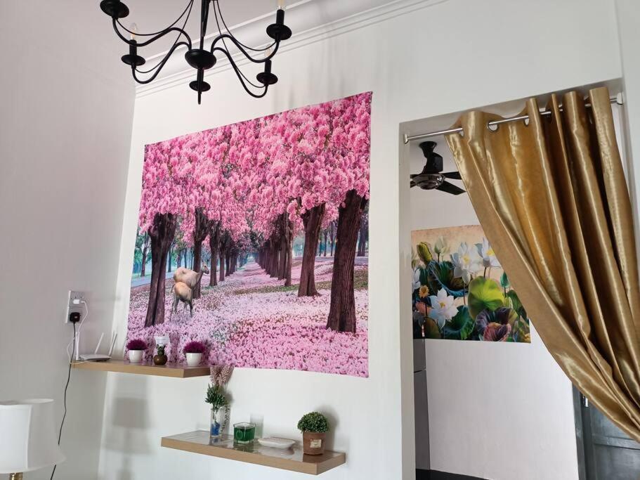 ein Gemälde rosa Blumen an der Wand in der Unterkunft Sweet 3 bedroom home @ Canning Garden, Ipoh in Ipoh