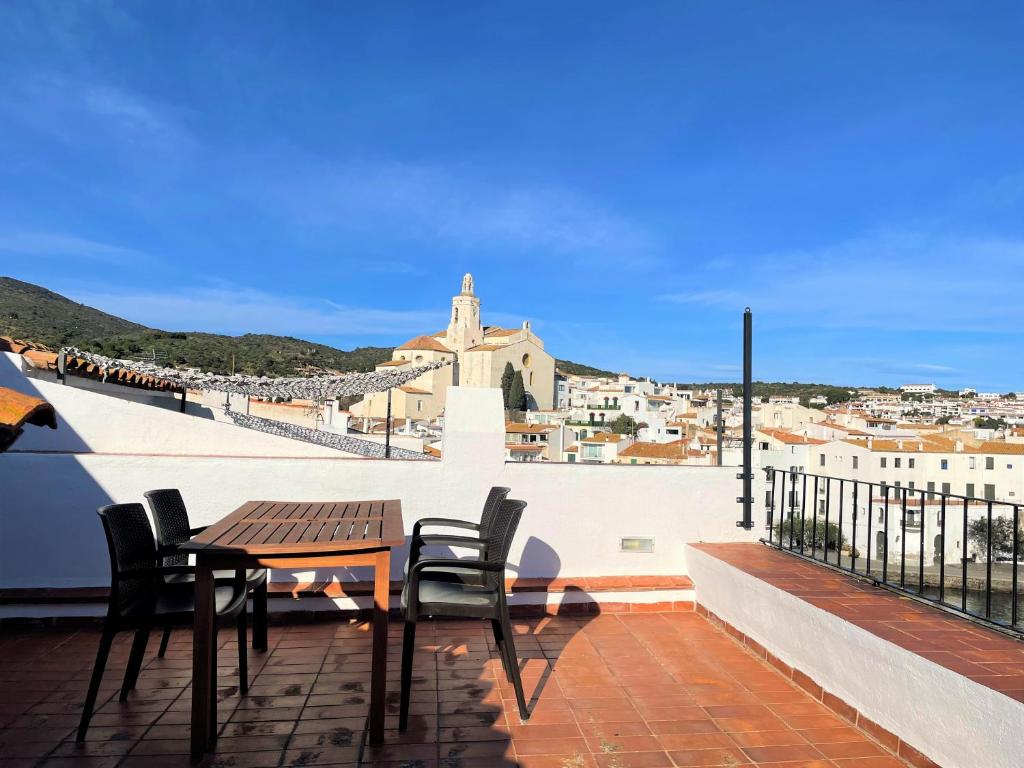 un tavolo e sedie sul tetto di un edificio di MARQUINA - Apartamento con fantásticas vistas al mar a Cadaqués