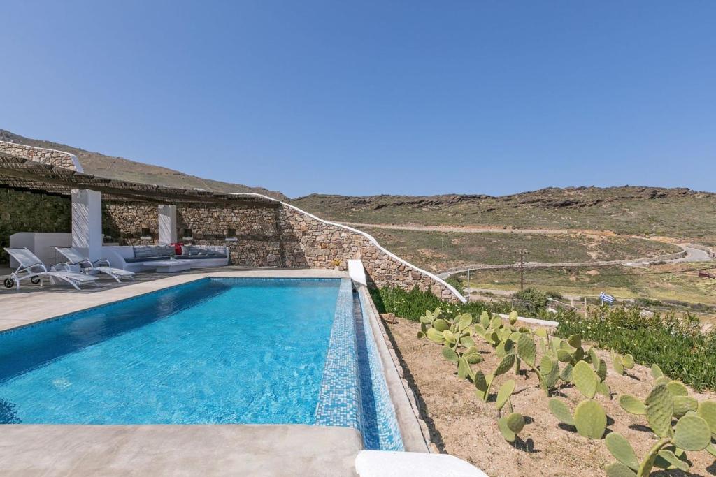a swimming pool in front of a house at Elegant Mykonos Villa Air Private Pool 4 Bedrooms Sea View Panormos in Mykonos