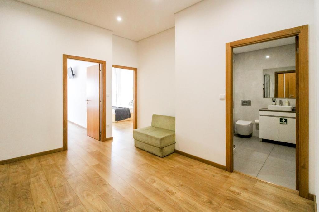 een woonkamer met een stoel en een spiegel bij Asgard Oporto Downtown Apartments in Porto