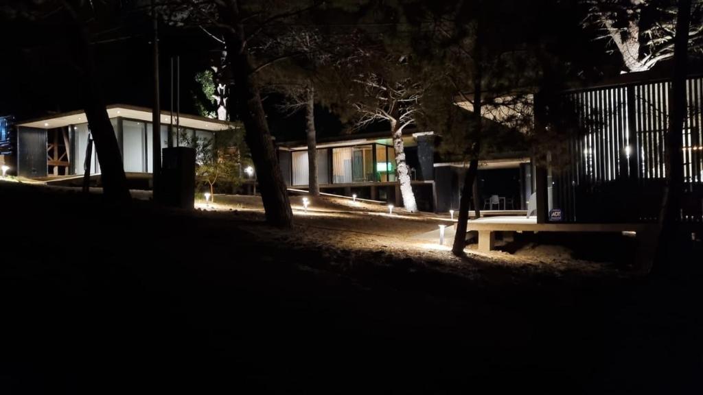 un banco del parque frente a una casa por la noche en Terrazas Pinar 4 en Monte Hermoso