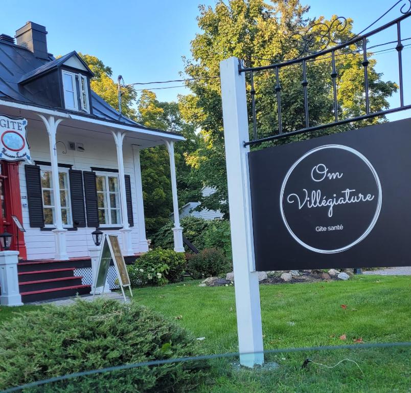 una señal frente a una casa en Om Villégiature en Saint-Laurent-de-l'ile d'Orleans