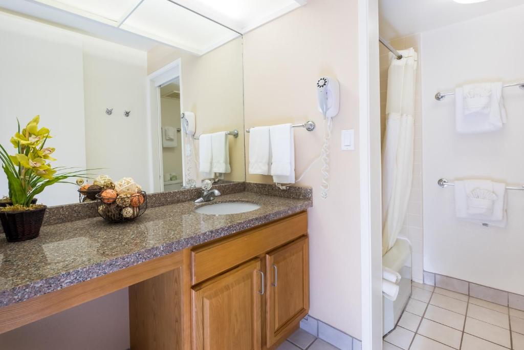 La salle de bains est pourvue d'un lavabo et d'un miroir. dans l'établissement Maui Schooner Resort, à Kihei