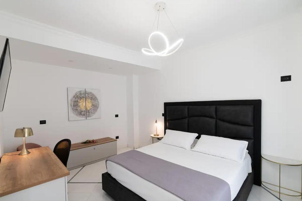 una camera con letto, tavolo e sedia di Apartments Hotel Real Suite Napoli Chiaia Mergellina a Napoli