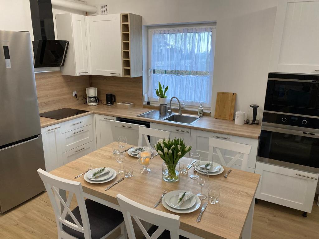 a kitchen with a wooden table with wine glasses on it at Diamentowa 7 Rent Home Konarzewo Poznań in Poznań