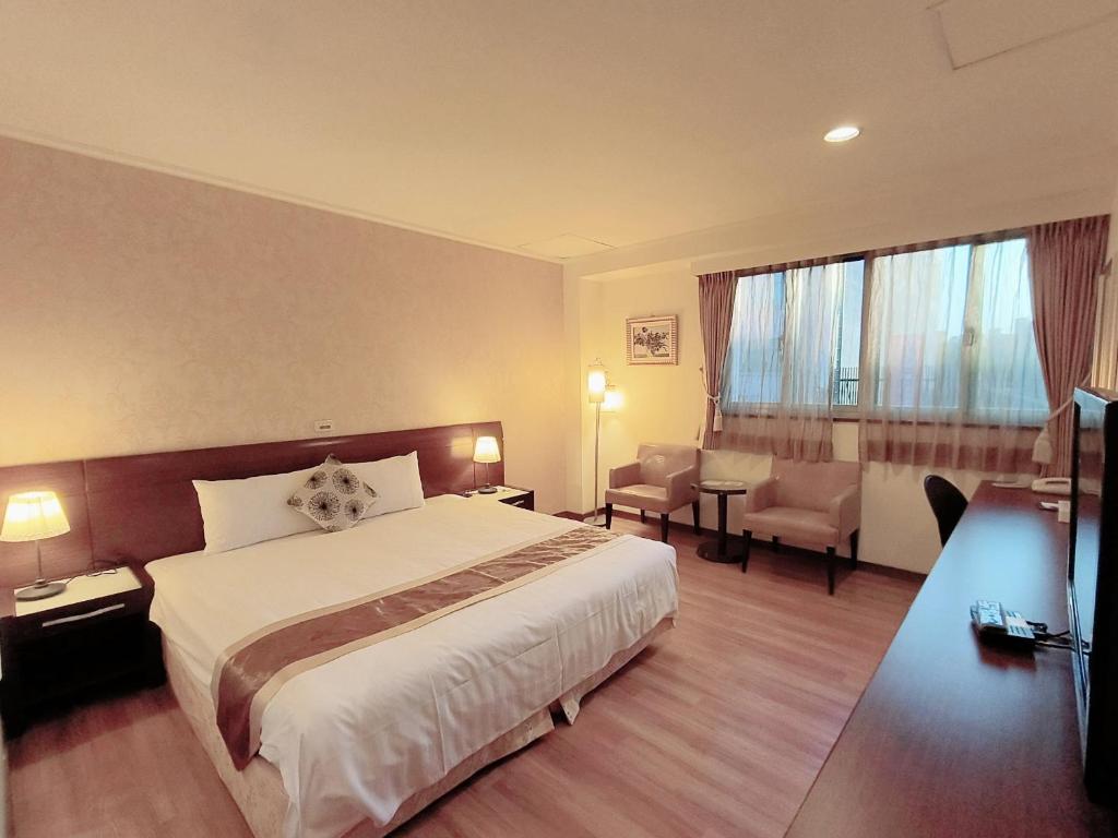 a hotel room with a bed and a large window at 文化信然 in Tainan